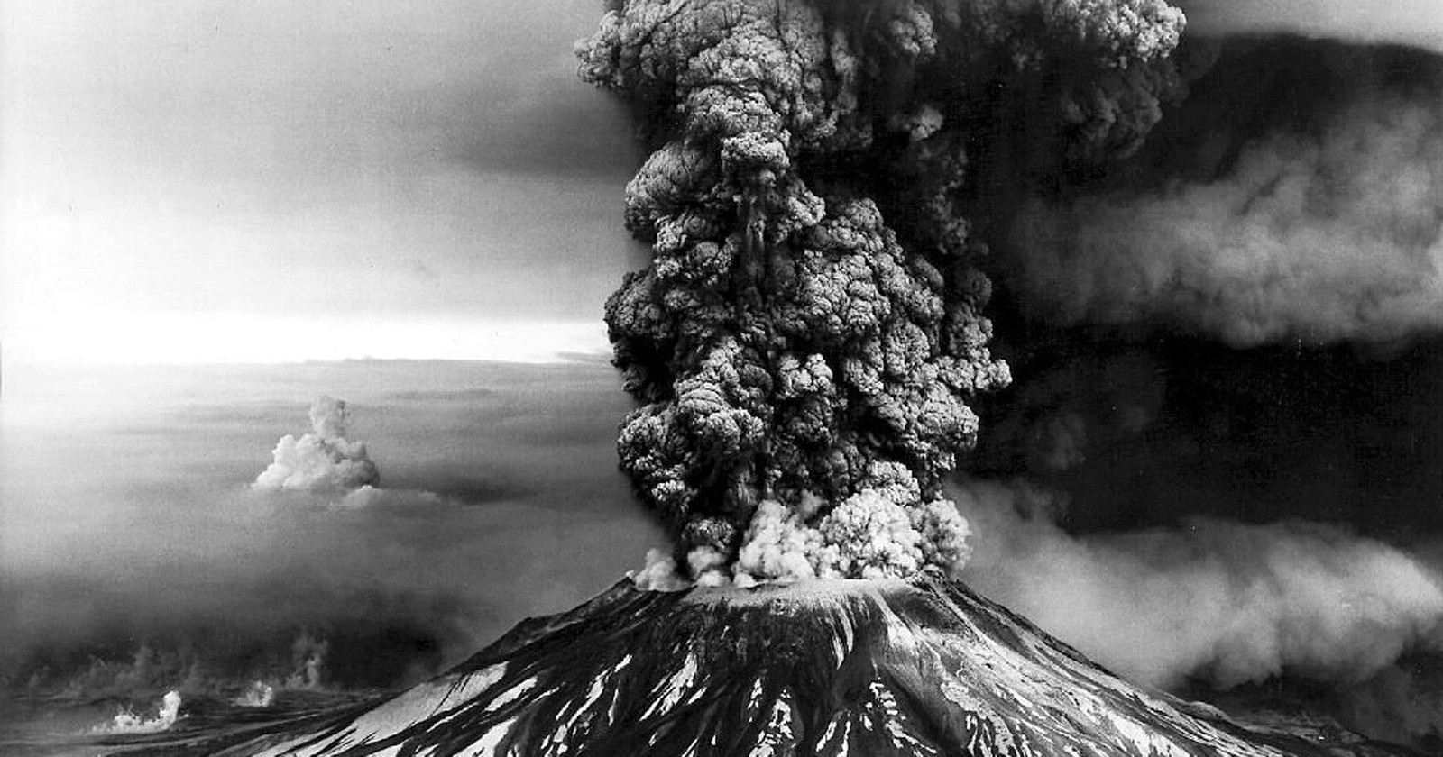 Uma foto em preto e branco de uma grande nuvem de fumaça subindo de um vulcão (vulcão, tipo de erupções vulcânicas, relevo vulcânico, árvore, cinzas vulcânicas)