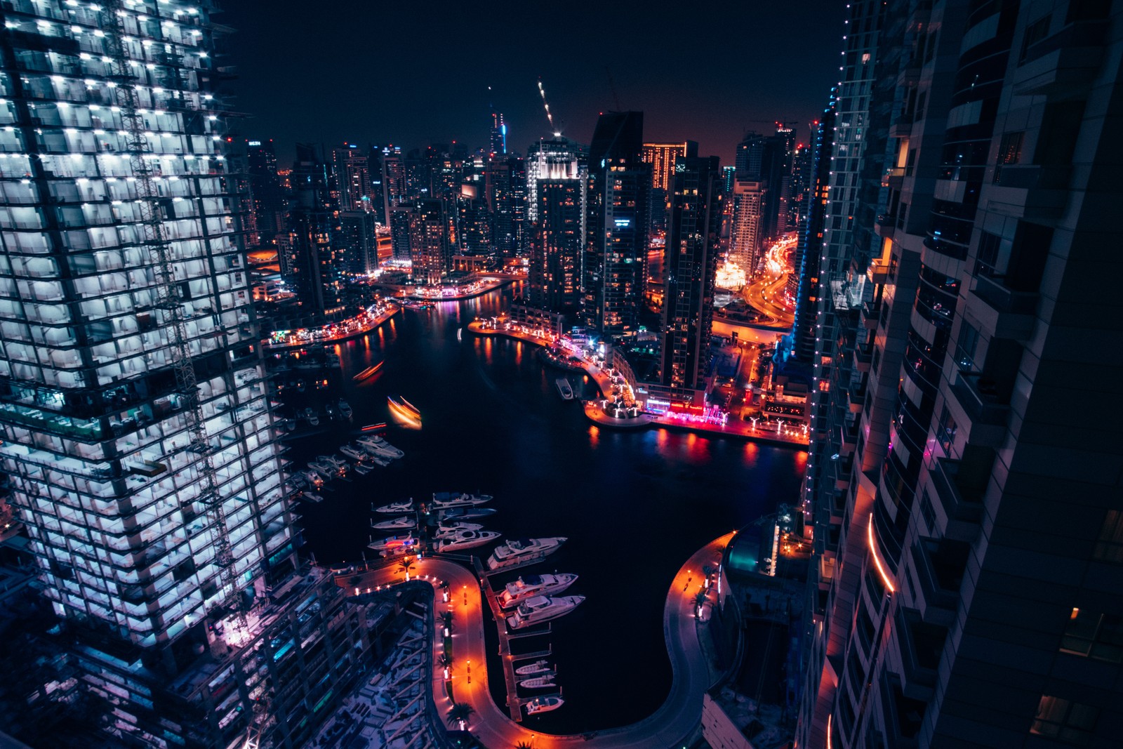 Eine ansicht einer stadt bei nacht mit booten und gebäuden (dubai marina, vereinigte arabische emirate, boote, stadtbild, moderne architektur)