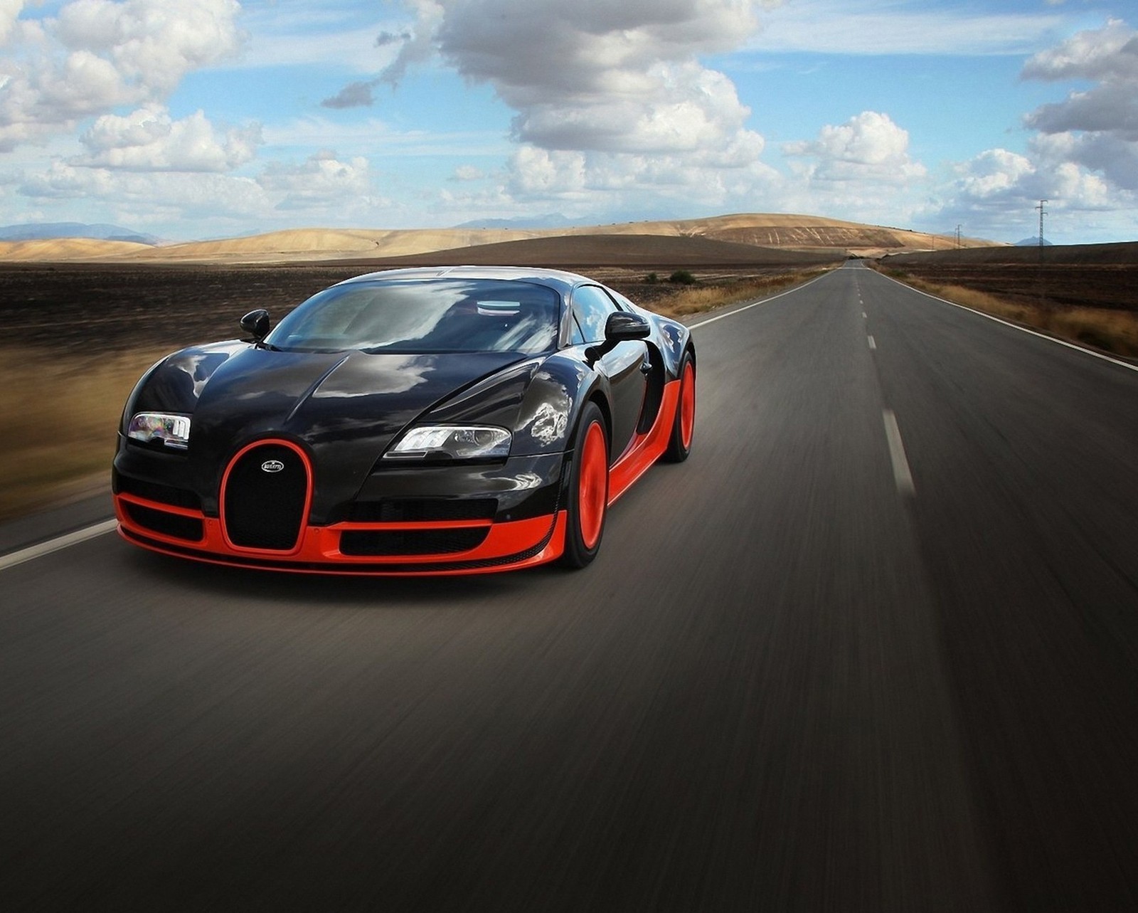 Gros plan d'une voiture bugatti roulant sur une route (voiture, nuages, route, vitesse, veyron)