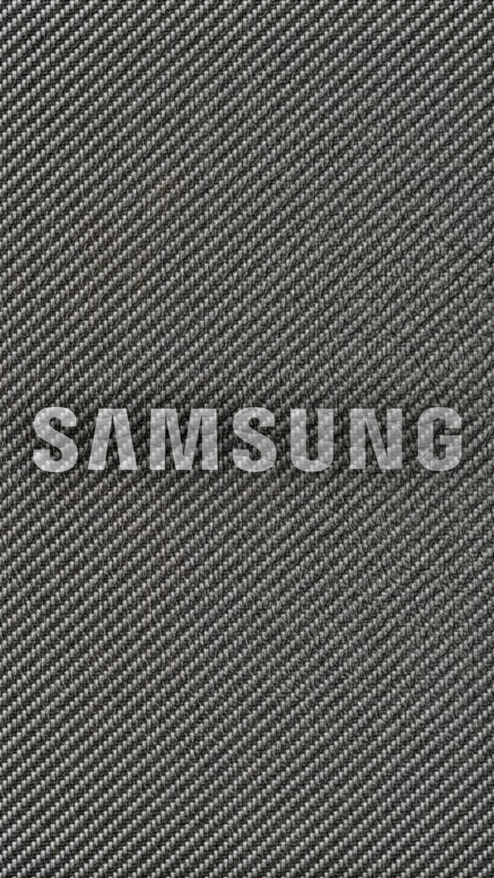 Un gros plan du logo samsung sur fond noir (carbone, sombre, noir, samsung, blanc)