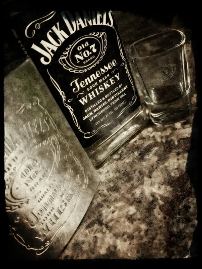 Jack Daniel's Tennessee Whiskey con un vaso de chupito sobre una superficie texturizada.