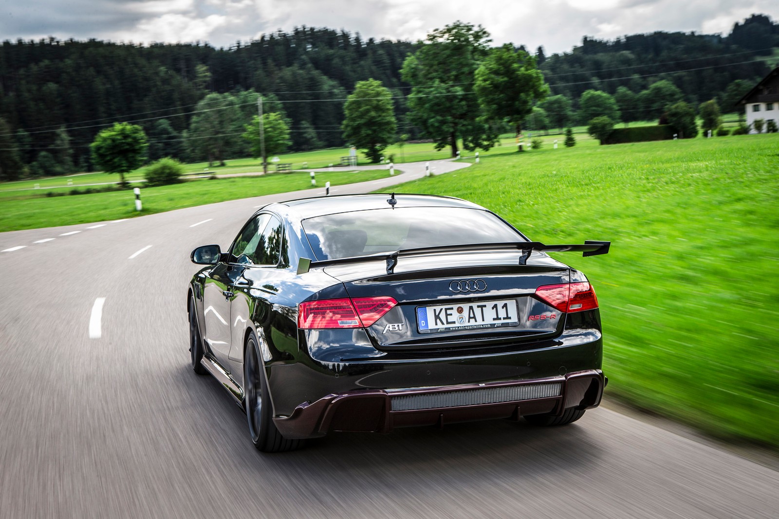 Une vue aérienne d'une voiture roulant sur une route de campagne (voiture, audi, audi rs5, abt sportsline, voiture de sport)