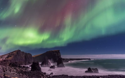 Aurora vibrante sobre a paisagem marítima islandesa