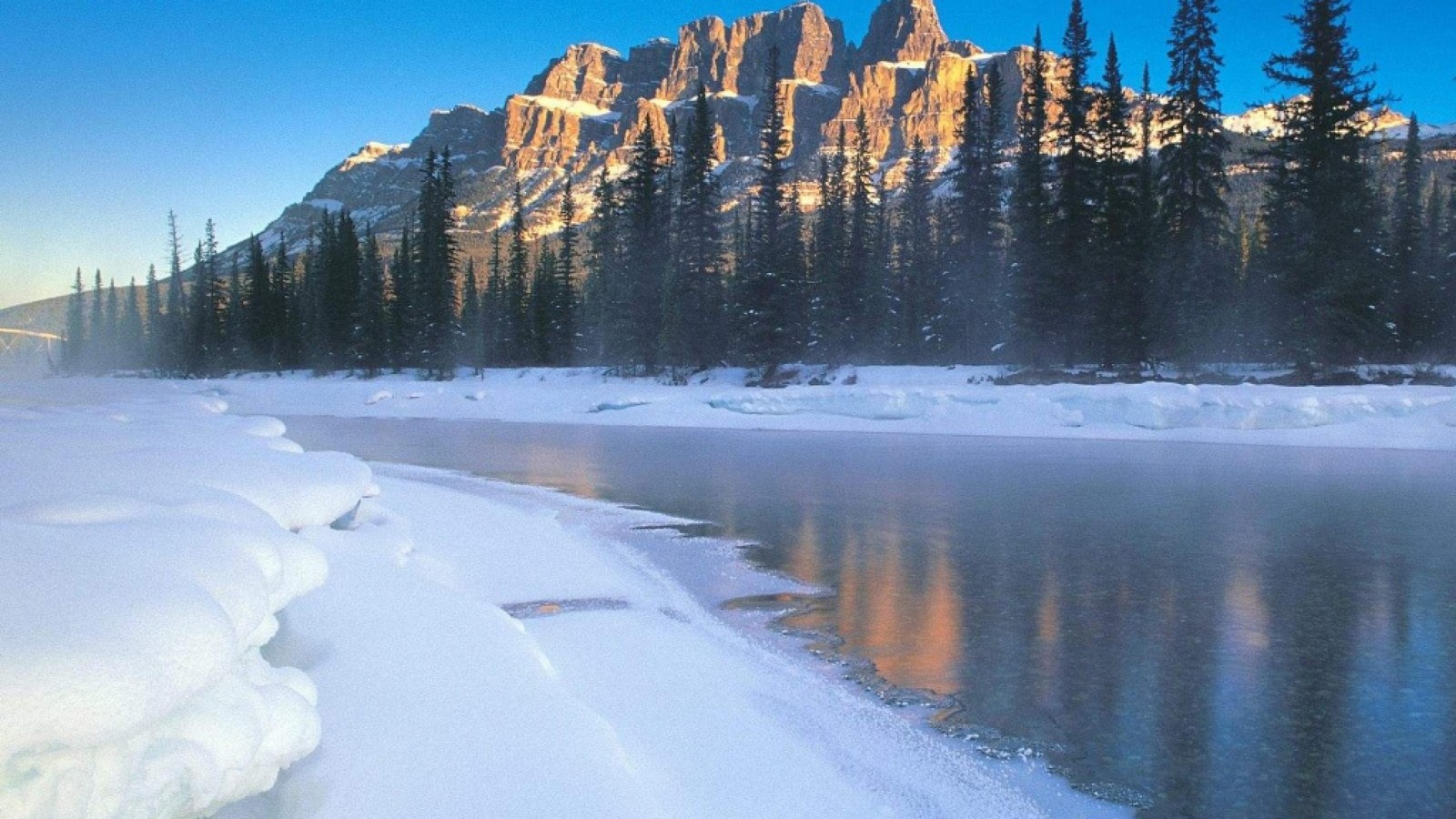 Montañas nevadas y un lago en medio de un bosque (montaña del castillo, montaña, naturaleza, nieve, paisaje natural)