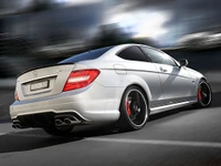 Mercedes-Benz AMG C-Class in dynamic motion with sleek alloy wheels and a sporty rear design.