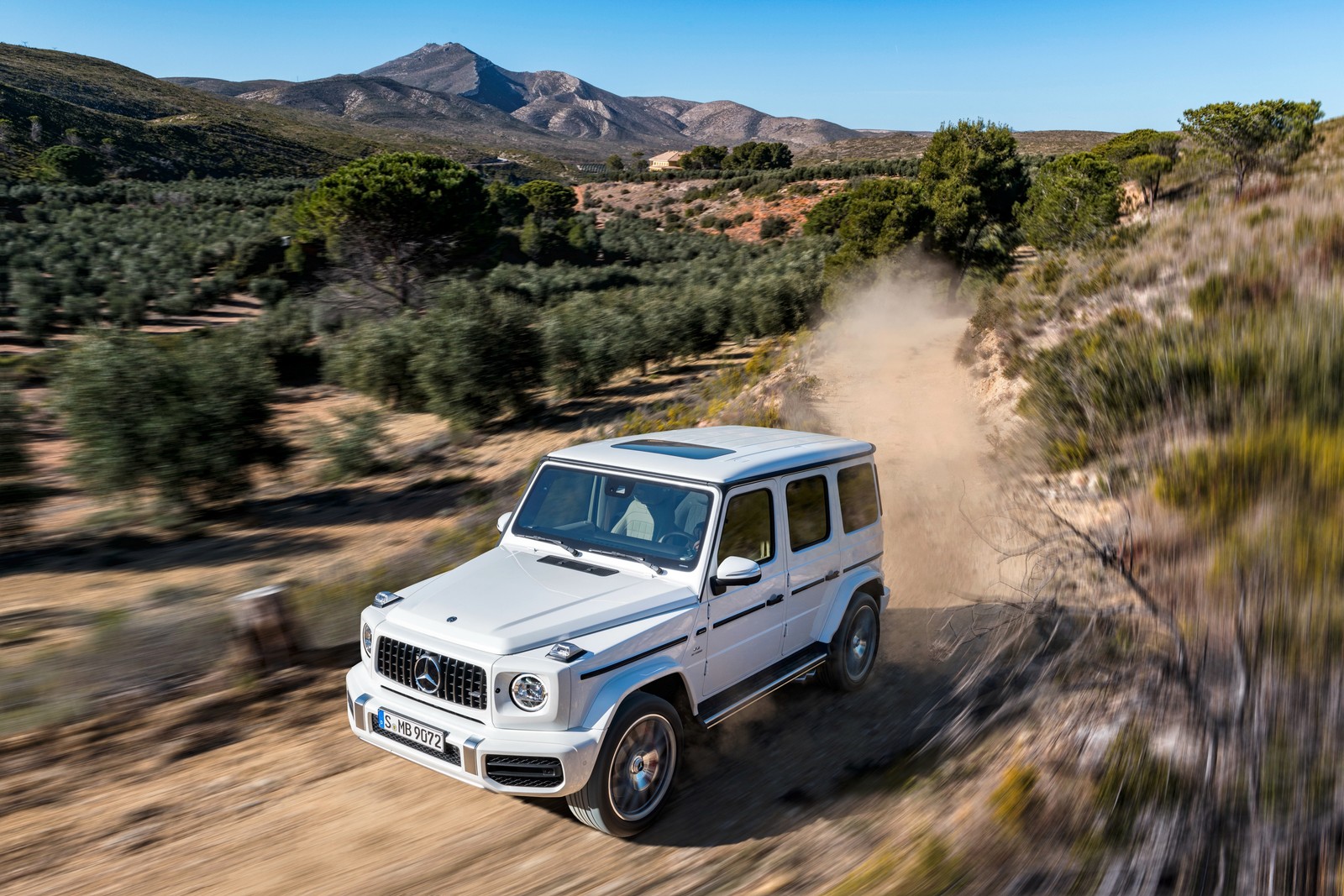 Ein weißer mercedes g-klasse fährt auf einem schotterweg (auto, offroad, straße, mercedes benz, gelände)