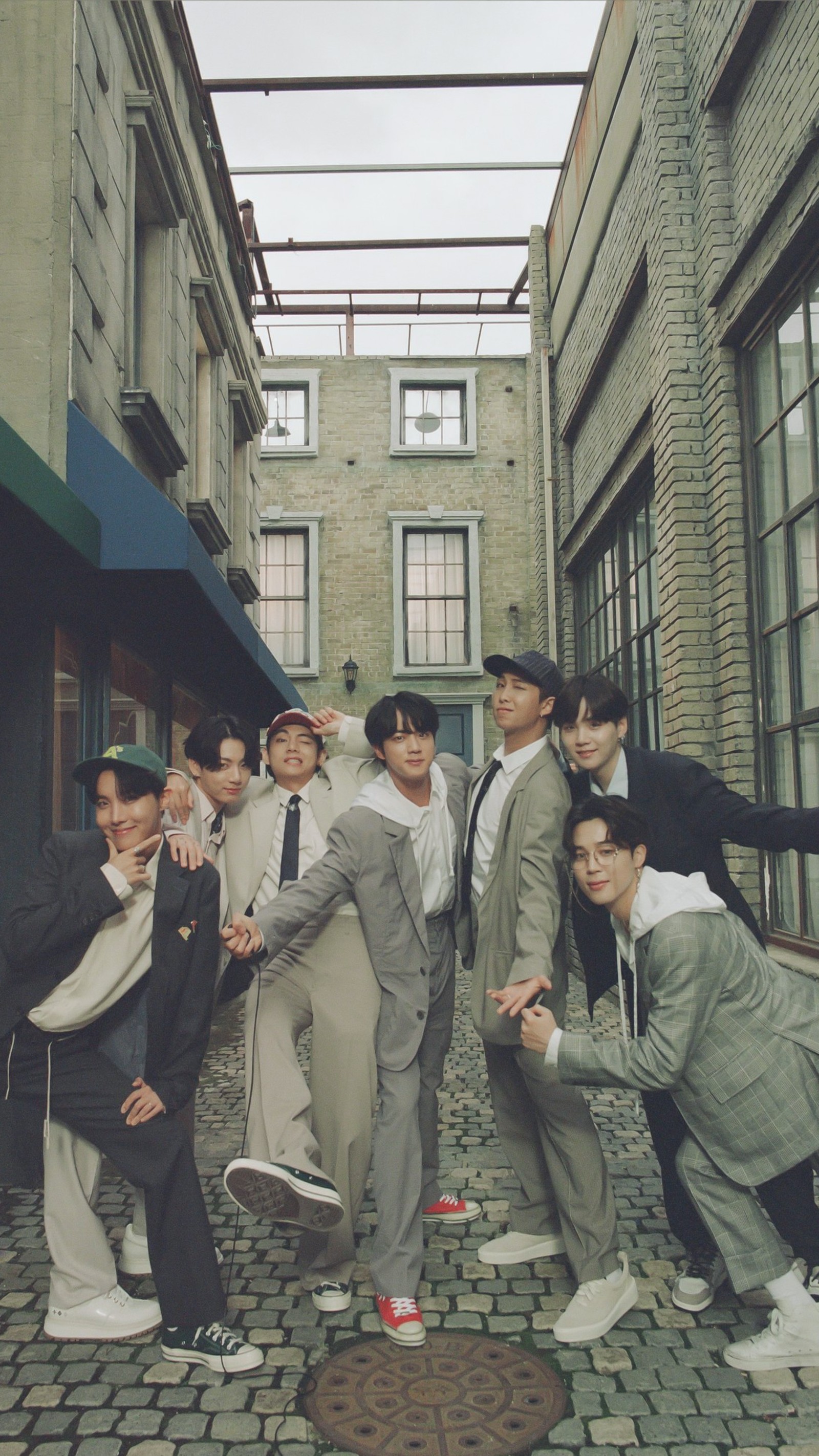 There are many people posing for a picture in a narrow alley (bangtan, bangtan sonyeondan, be, be album, bts)