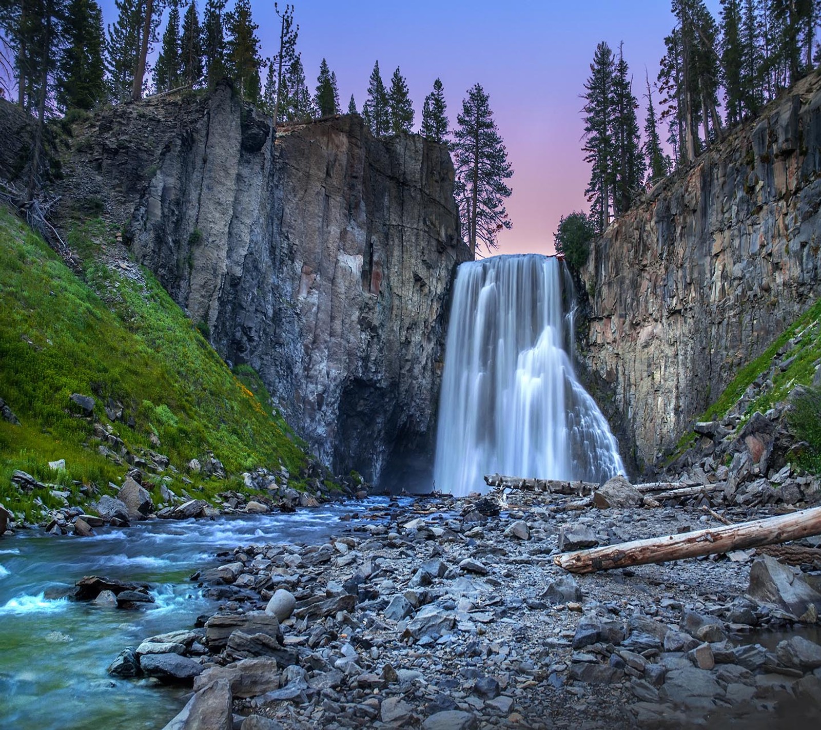 Cascade floue au milieu d'un ravin rocheux avec un ciel rose (regard, sympa)