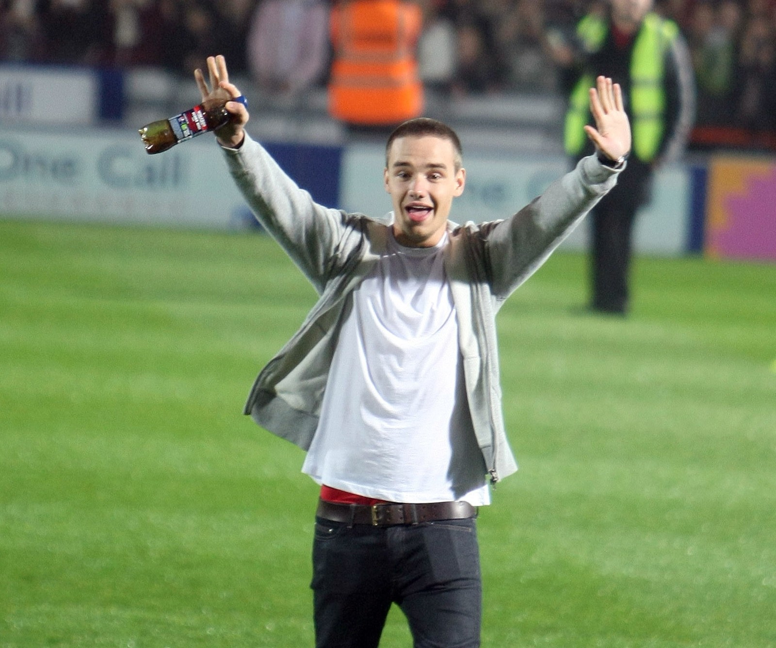 Homem arafed com camisa branca e calças pretas segurando uma garrafa de cerveja (menino, britânico, fofo, liam payne, one direction)