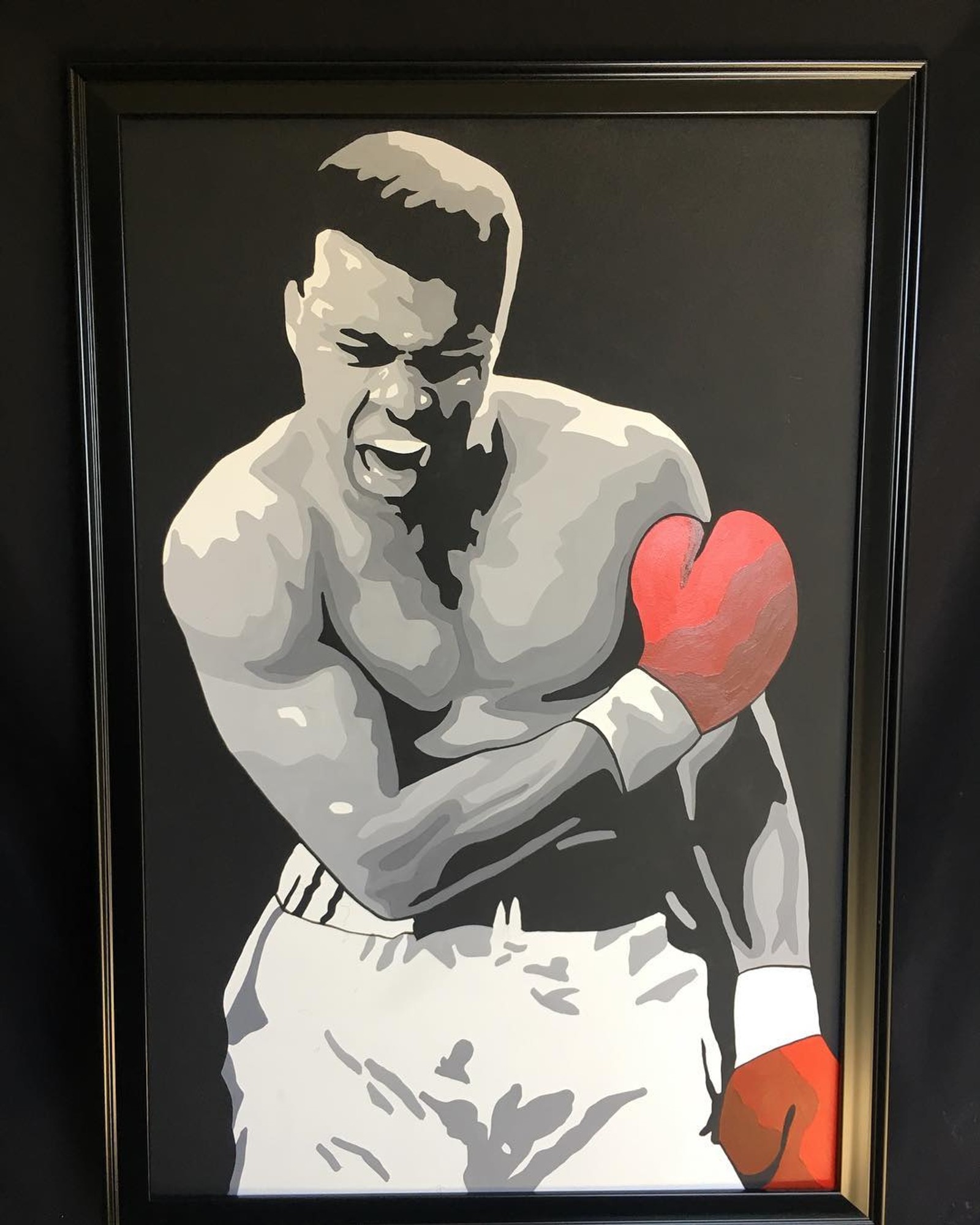 Painting of a man with a boxing glove in a black frame (ali, mahomad)