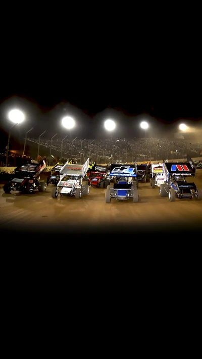 Ação de corrida noturna: carros de sprint na pista de terra 410