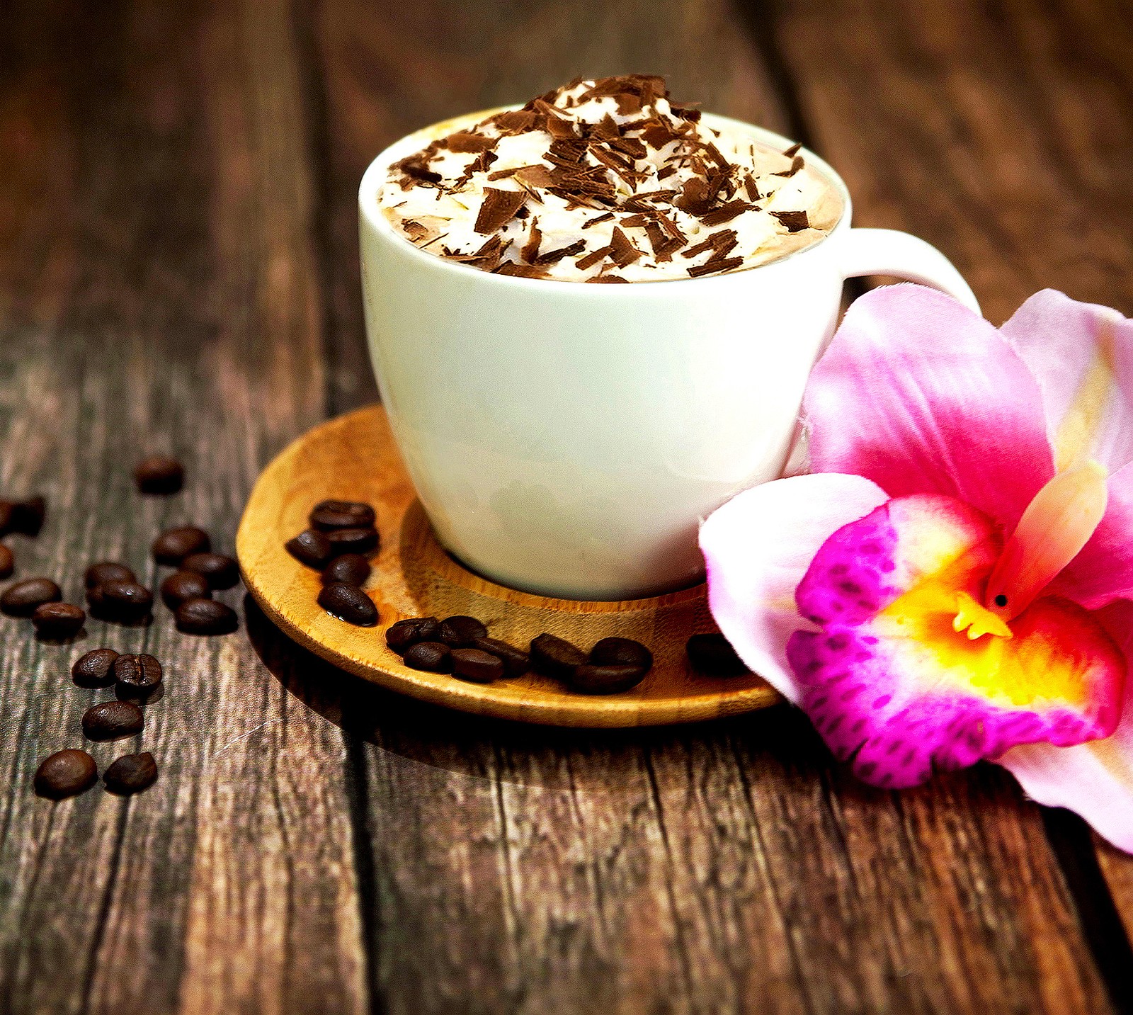 There is a cup of coffee with a flower on a plate (cappuccino, chocolate, coffee bean, flower, hd)