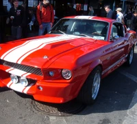 Klassischer roter Mustang mit Rennstreifen und begeistertem Publikum