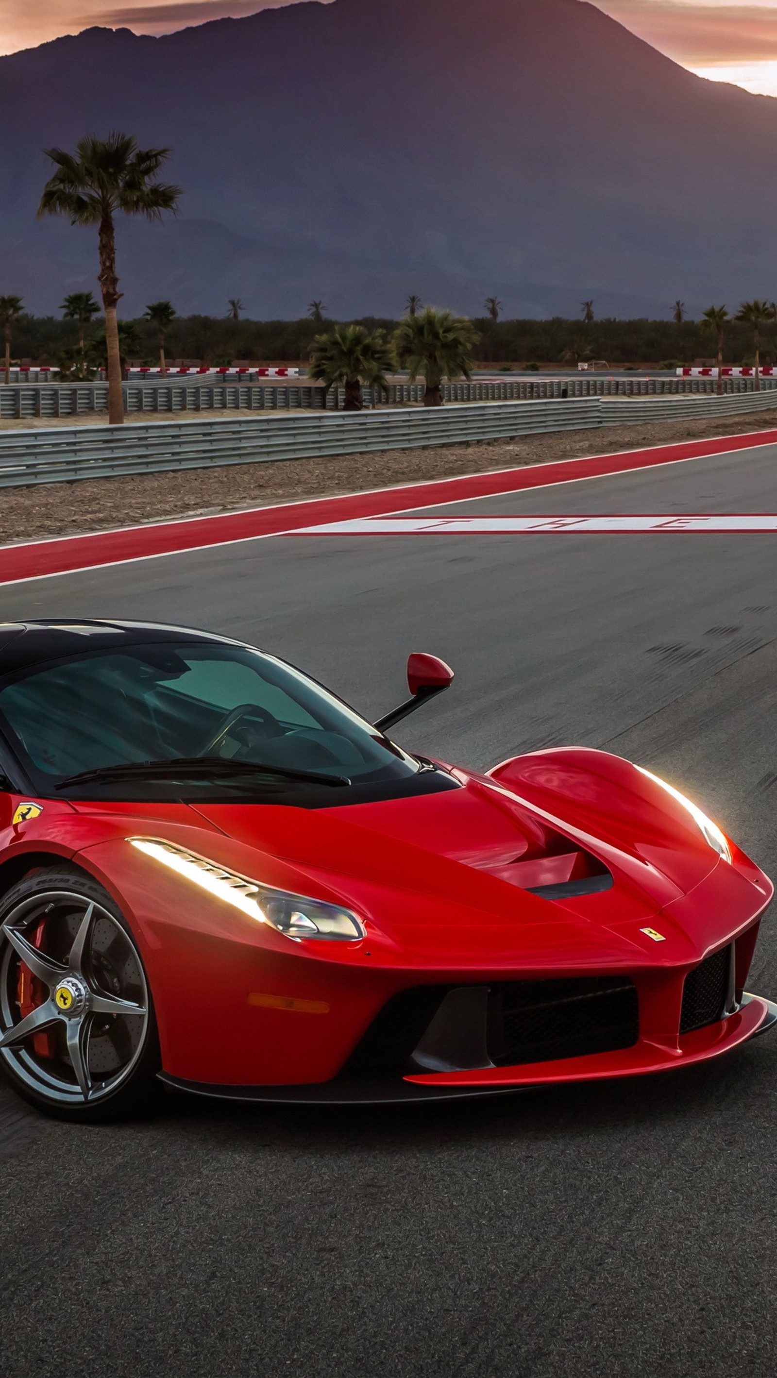 Arafed red sports car driving on a track with mountains in the background (ferrari, laferrari)