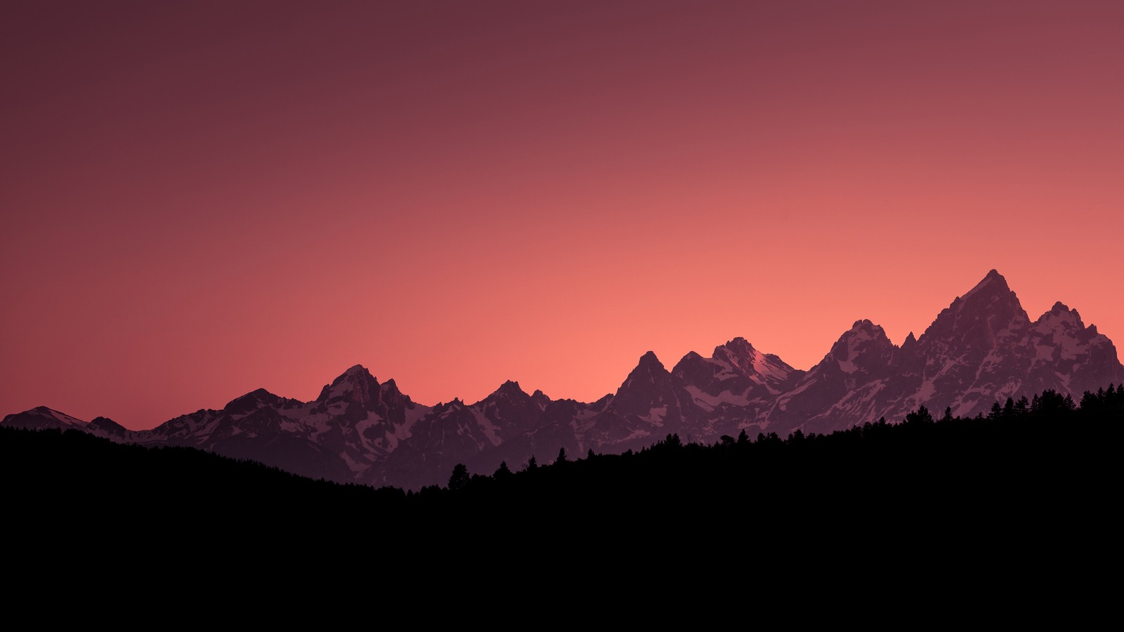 Uma vista de uma cadeia montanhosa com um céu rosa ao fundo (montanha, paisagem, cenário)