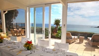 Deslumbrante villa com vistas panorâmicas do oceano e uma elegante configuração de jantar.