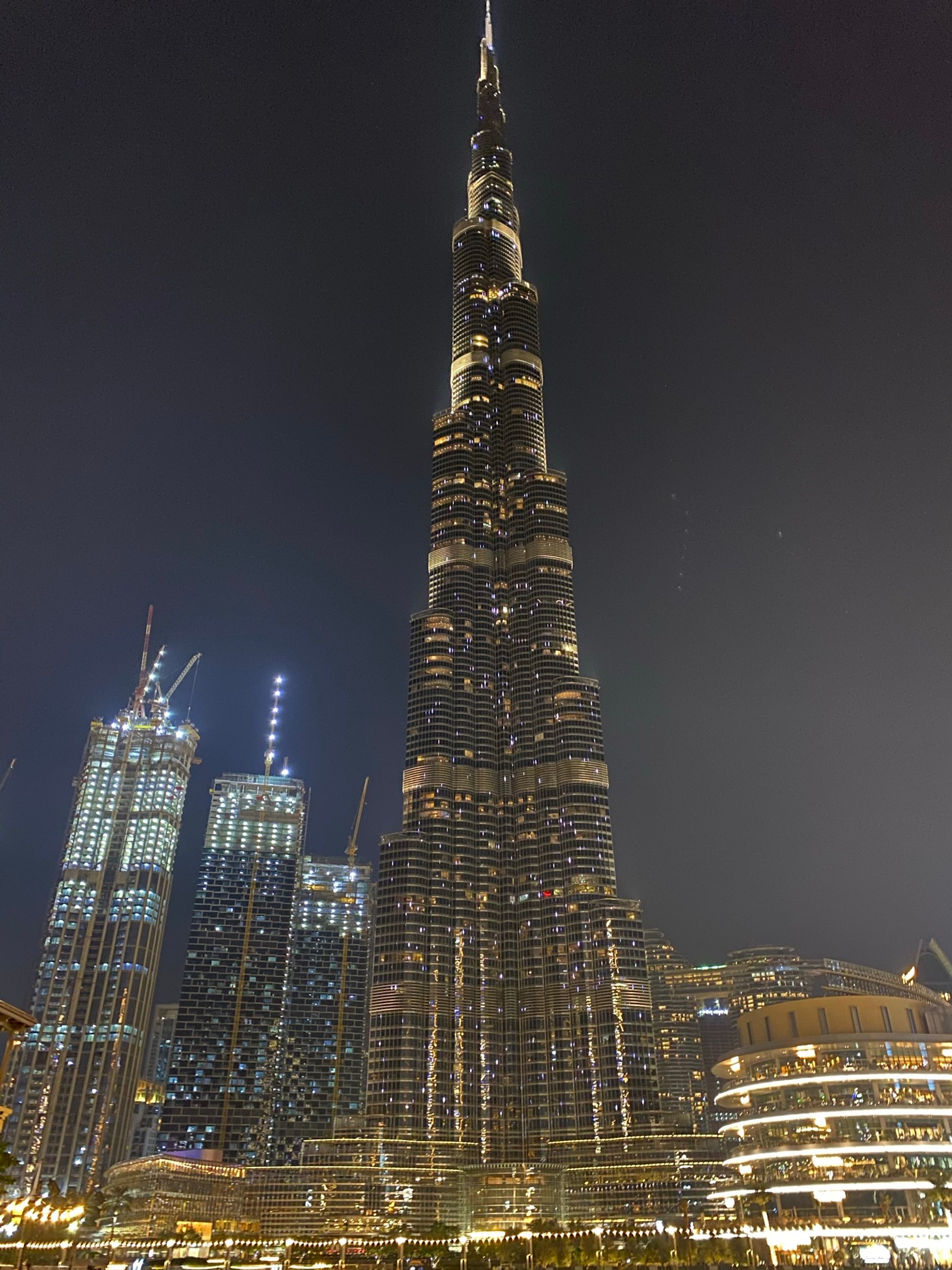 Vista de um prédio alto com muitas luzes nele (dubai, burj khalifa, turismo, atração turística, noite)