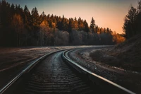 Vía de tren curva bañada en la luz de la hora dorada