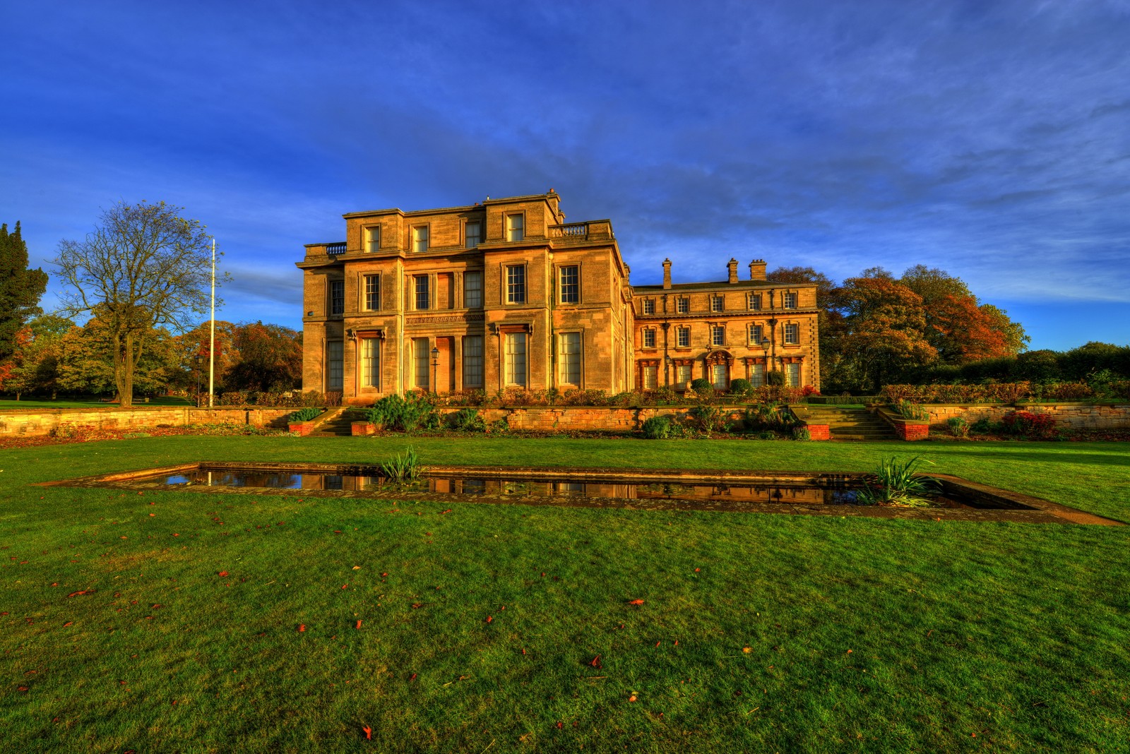 A view of a large building with a fountain in the middle of a field (building, estate, landmark, house, property)