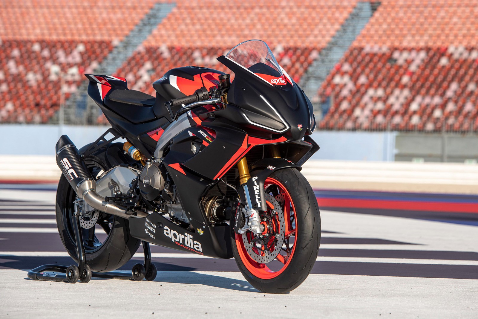 Ein abgestelltes motorrad auf einer rennstrecke mit einem roten und schwarzen reifen (aprilia rs 660 trofeo, sportmotorräder, 2021, fahrräder, 4k hintergrund)