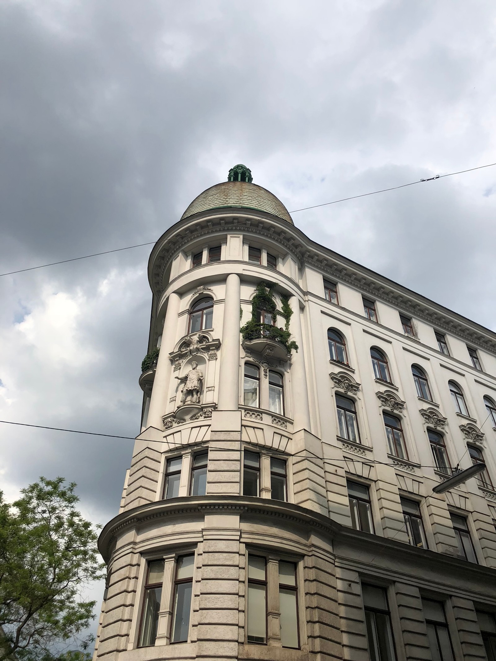 Il y a un grand bâtiment avec une horloge au sommet (point de repère, architecture classique, bâtiment classé, fenêtre, nuage)