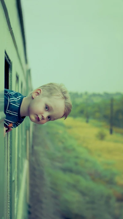 Child Gazing Out of Train Window Amidst Lush Landscape