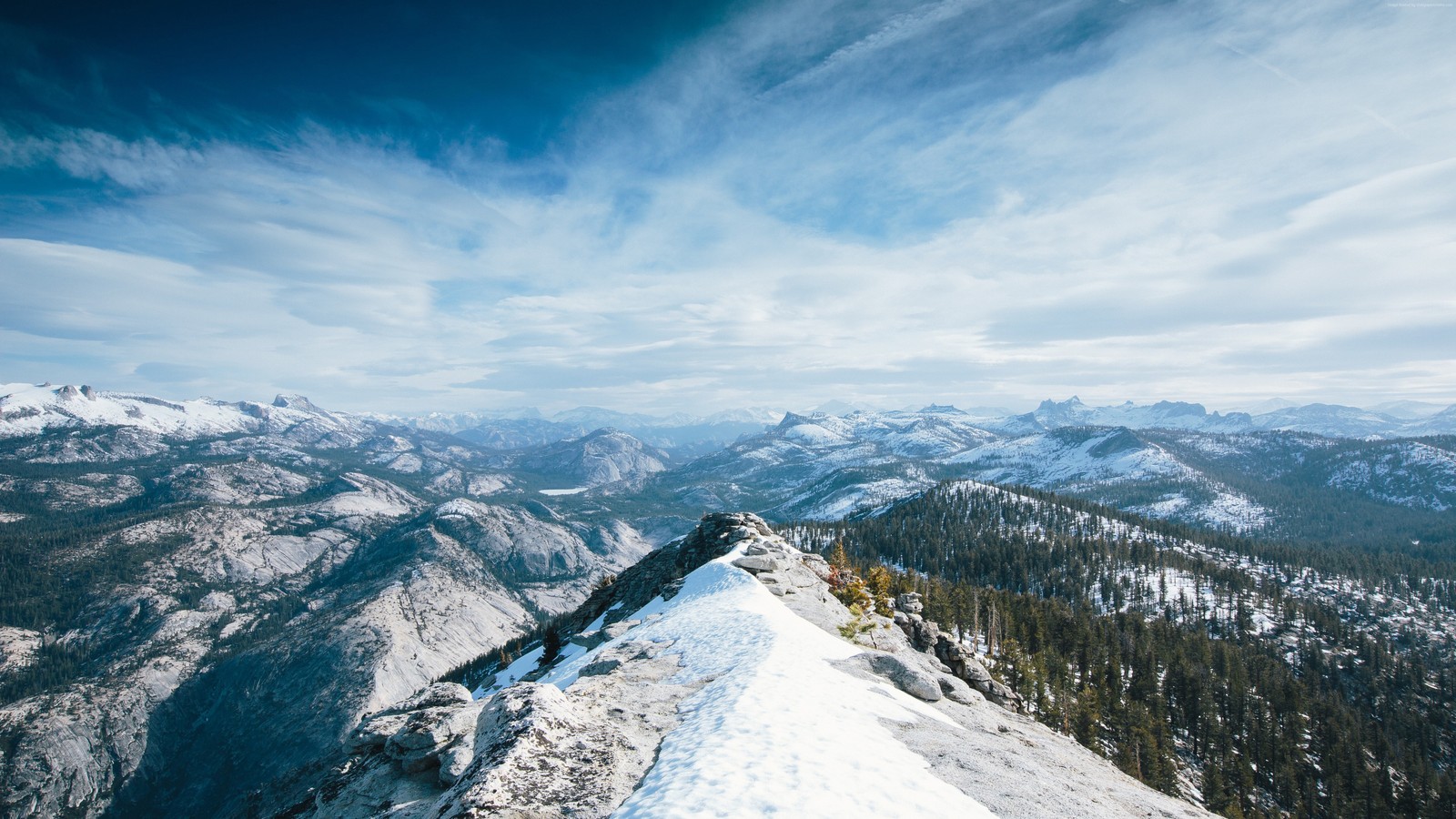 Uma vista de uma cadeia de montanhas nevadas com algumas árvores (montanhas, paisagem, natureza, cenário)