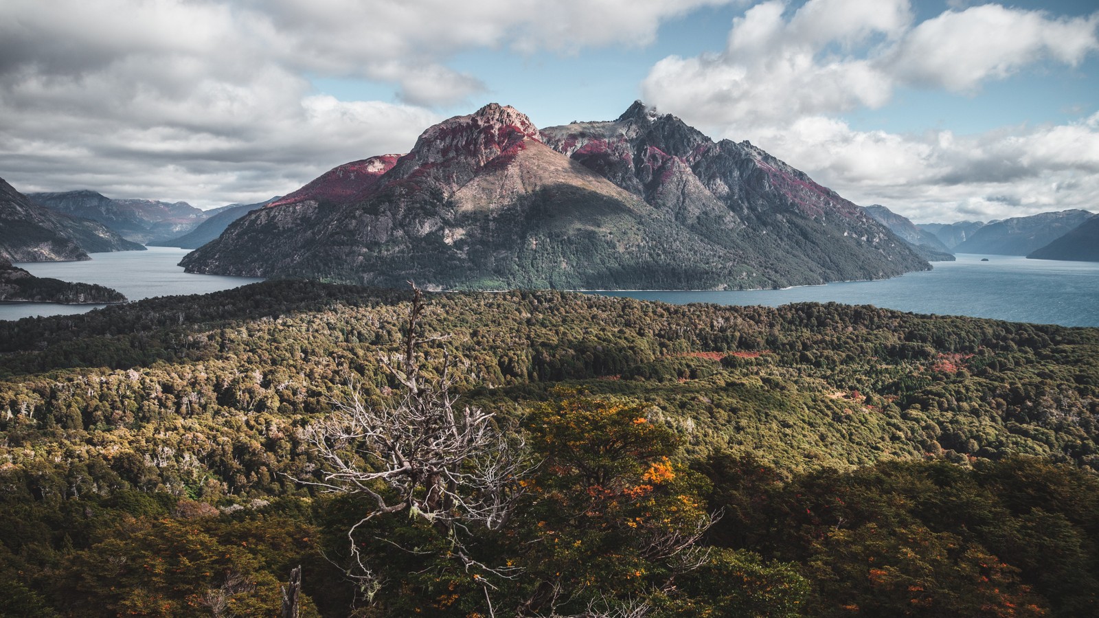 A view of a mountain range with a lake and mountains in the background (mountain range, mountain, cloud, water, plant)