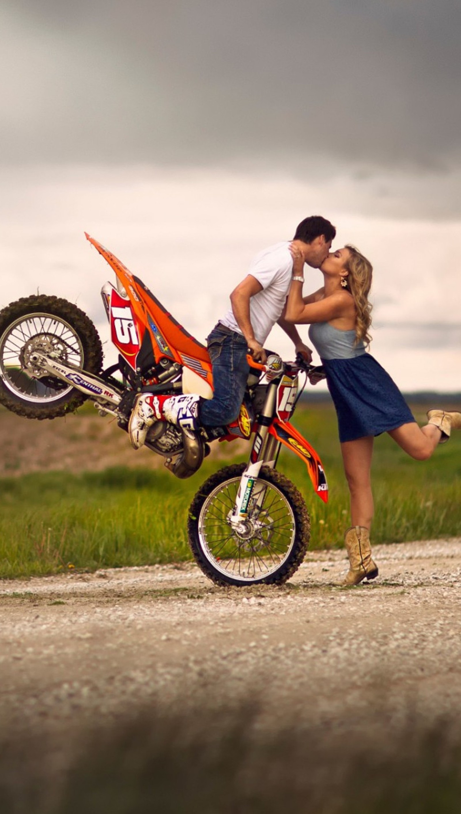 Ils s'embrassent sur une moto sur une route en terre (garçon, fille, baiser, amour, moteur)