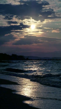 Gelassener Sonnenuntergang über sanften Wellen an einem ruhigen Strand