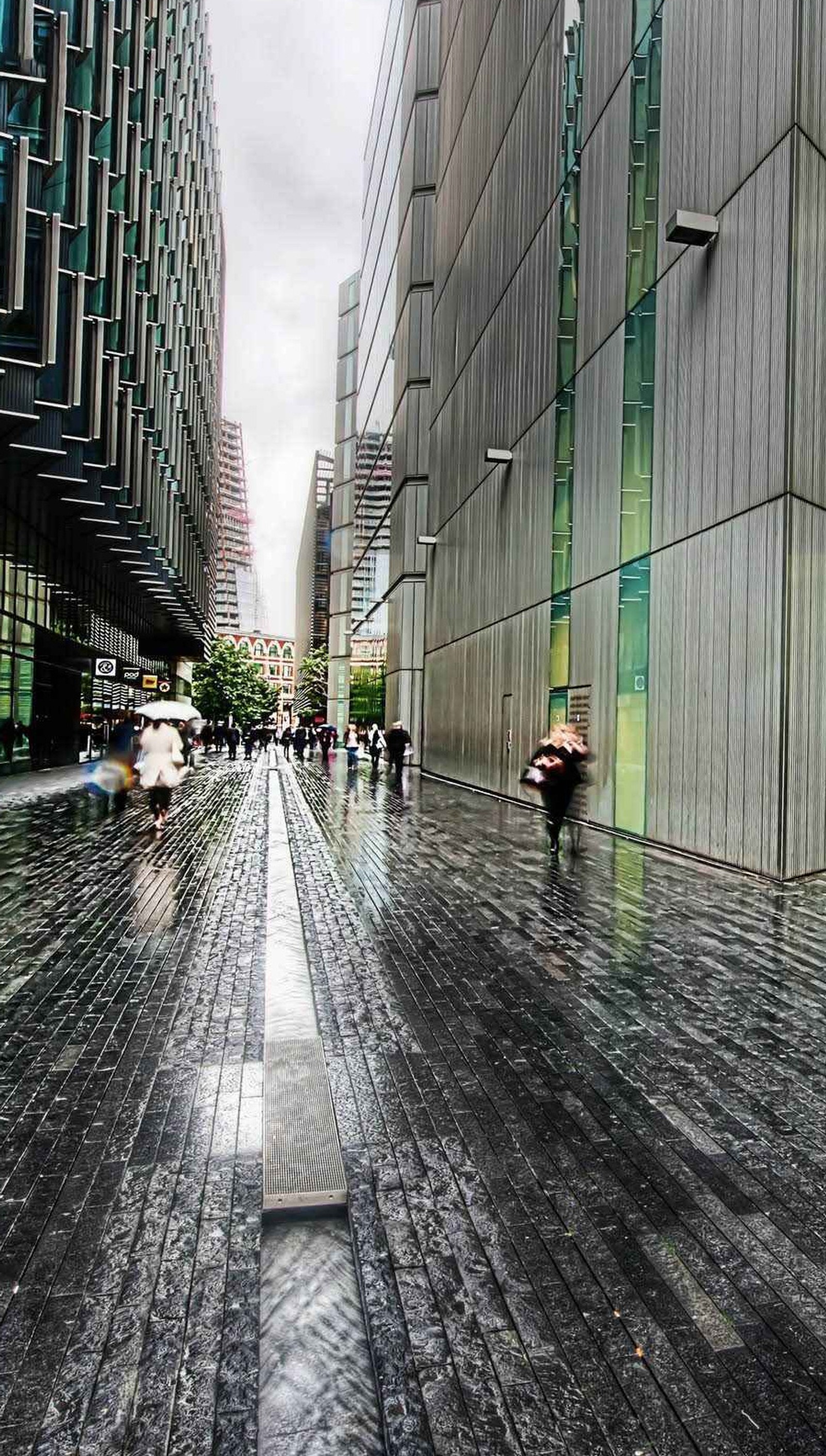 Hay personas caminando por la calle bajo la lluvia con paraguas (avenida, ciudad, lluvia, lluvioso, camino)