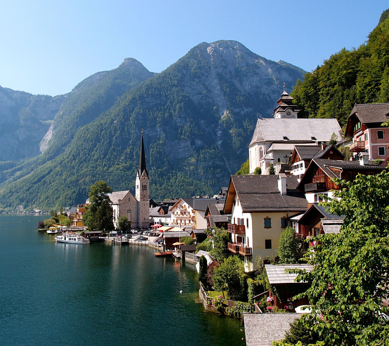 Vista aérea de una ciudad en un lago con montañas al fondo (austria, ciudad, lago, montaña, pueblo)