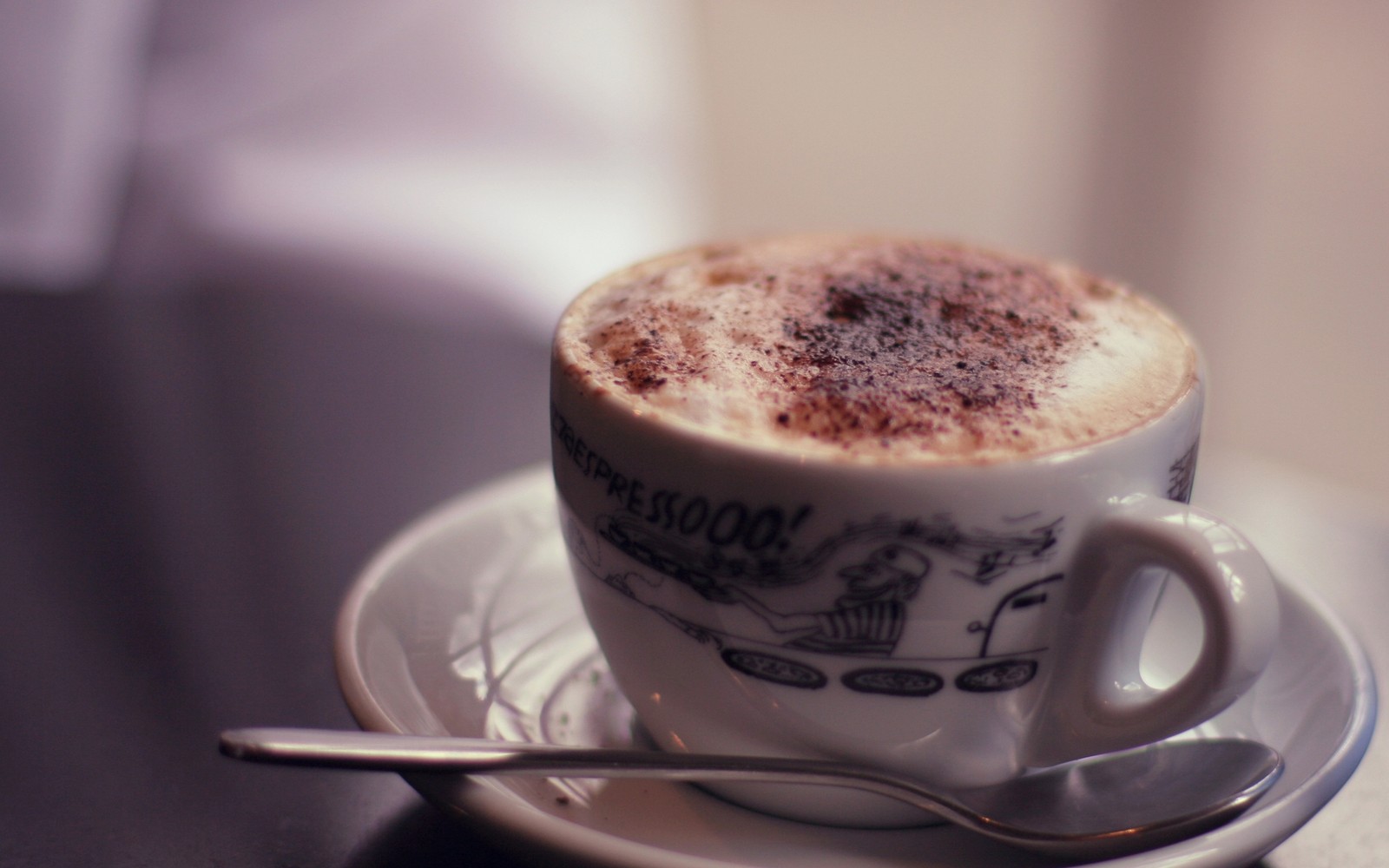 Es gibt eine tasse kaffee mit einem löffel auf einer untertasse. (cappuccino, espresso, milch, essen, wiener melange)