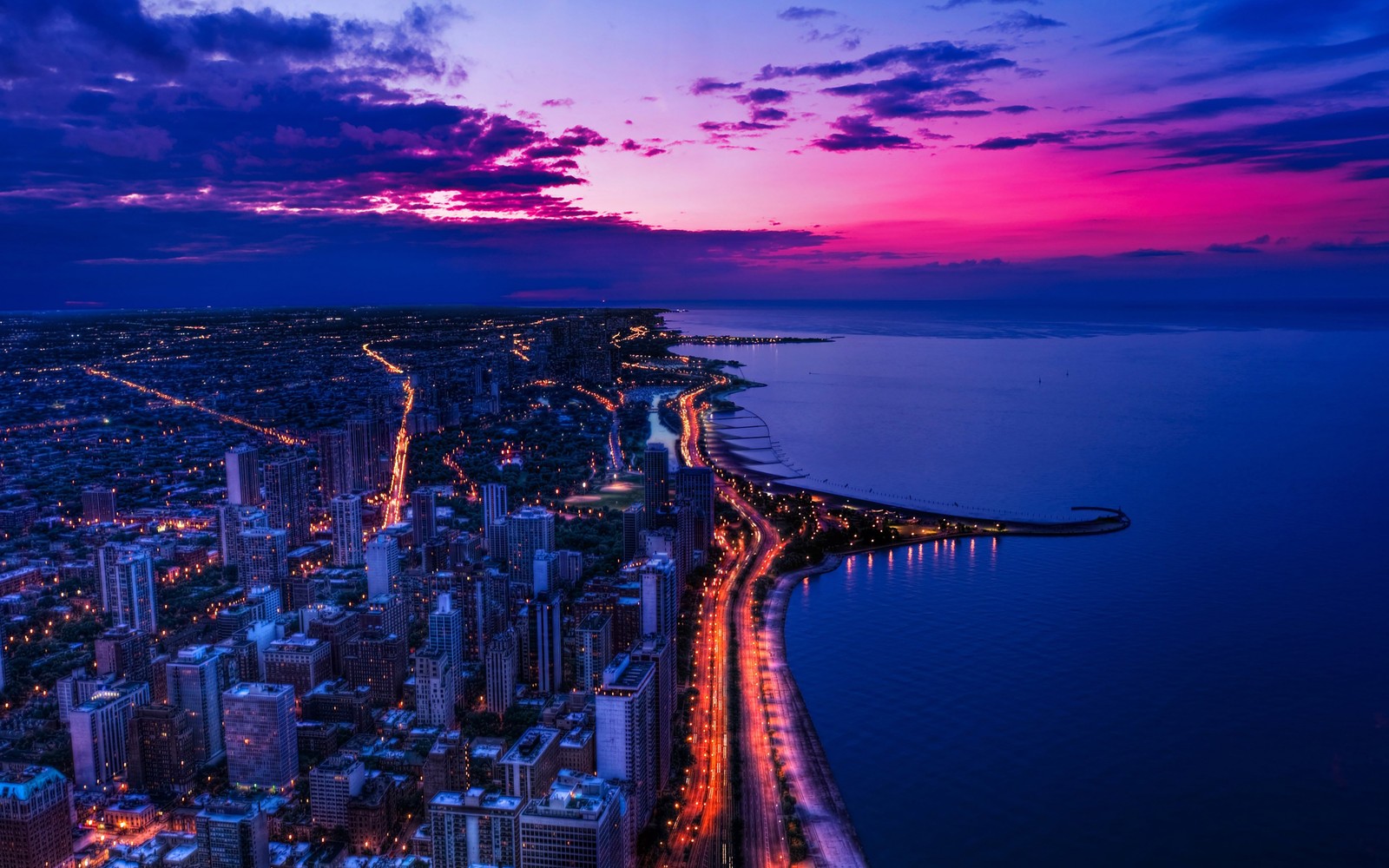 Vista de uma cidade à noite com um céu roxo (paisagem urbana, cidade, crepúsculo, horizonte, metrópole)