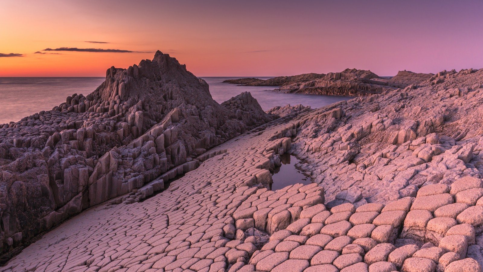 Il y a une vue d'une plage rocheuse avec un petit plan d'eau (terre, nuage, paysage naturel, socle, ensoleillement)