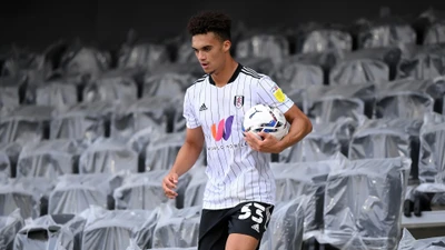 Antonee Robinson im Fulham FC Trikot mit Fußball auf dem Stadionfeld