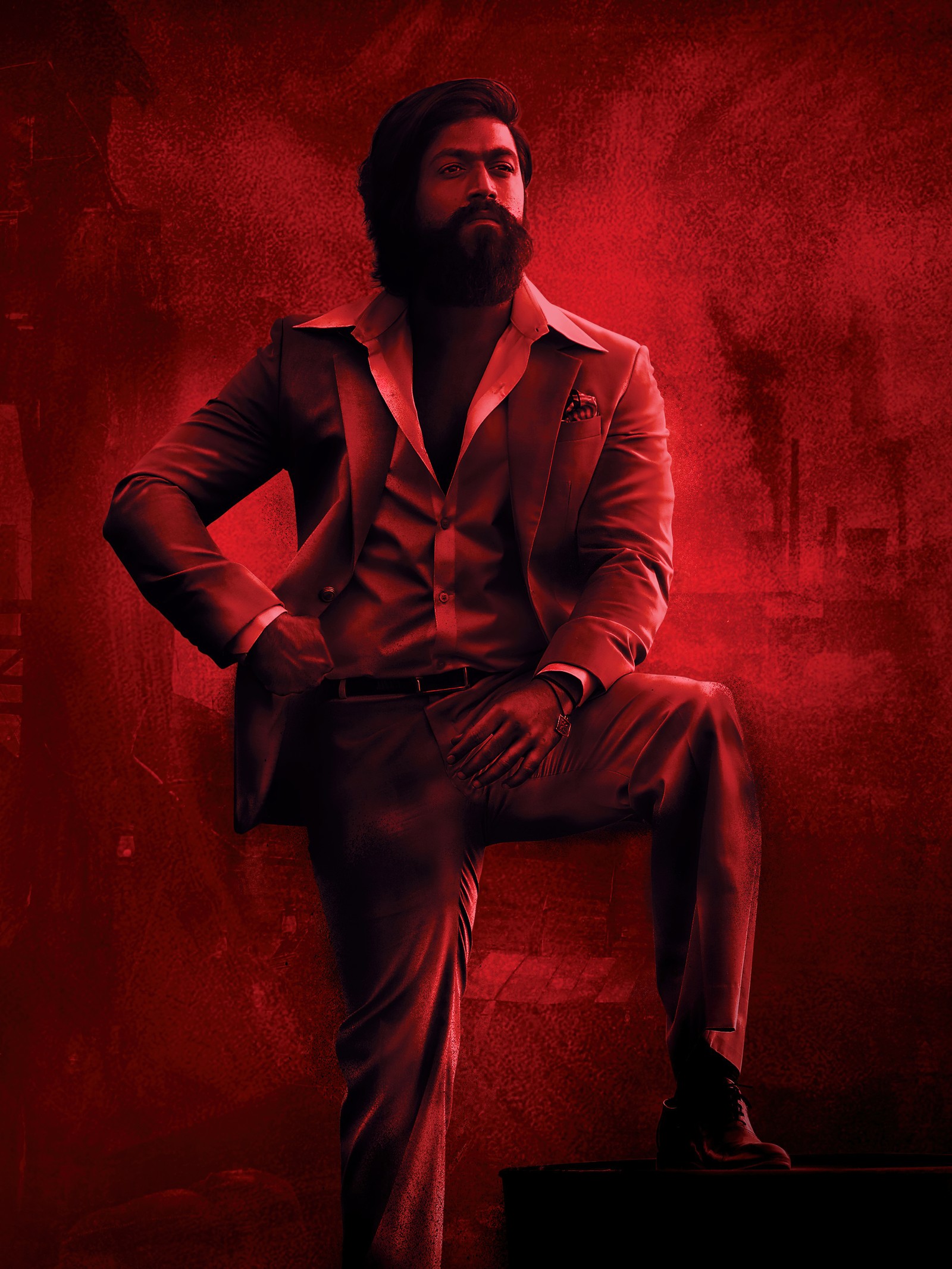 Un homme en costume est assis sur une valise (kgf chapitre 2, kgf chapter 2, yash, films indiens, films 2022)