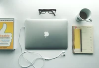 Espace de travail minimaliste avec MacBook, lunettes et café