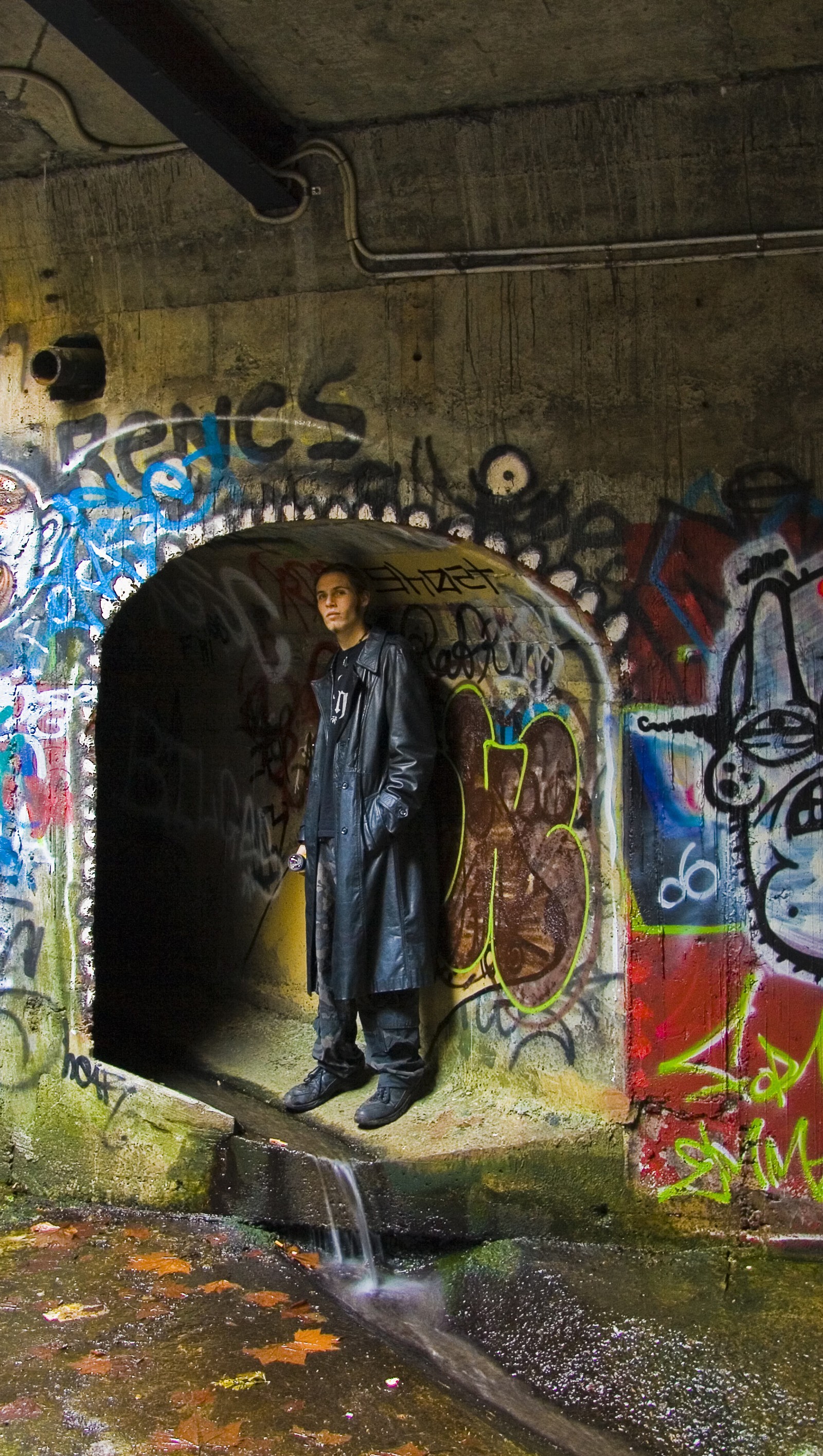 Un hombre árabe de pie en un túnel con grafitis en las paredes (arte, asombroso, grafiti, urbano, wallpaint)