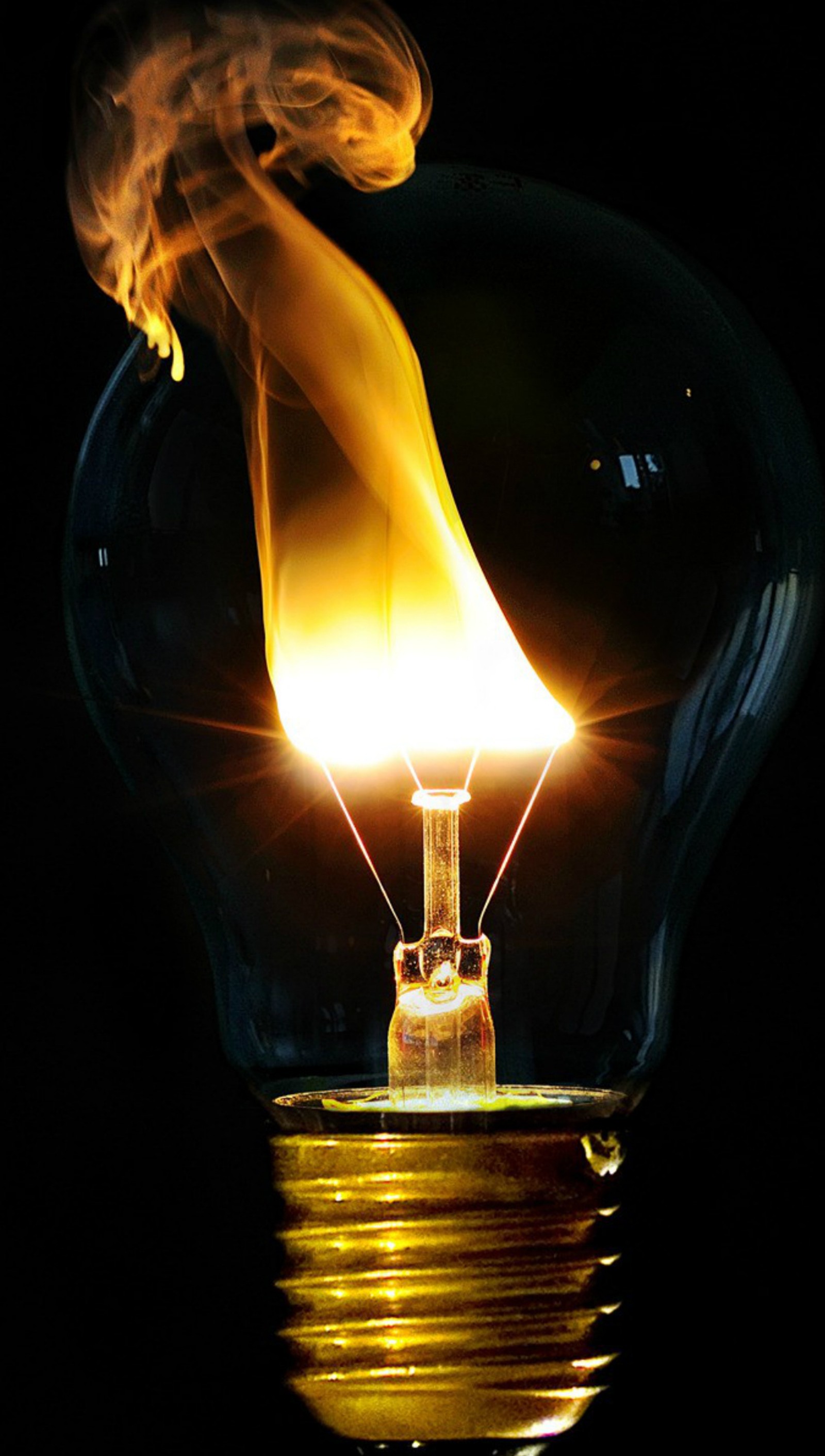 Arafed light bulb with a flame inside of it (black background, bulbs, fire, light)