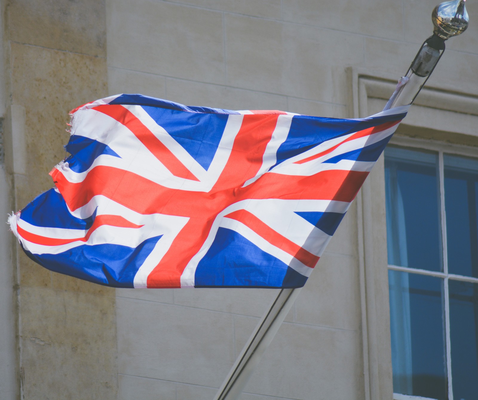 A bandeira árabe britânica voando em frente a um prédio com janelas (atleta, olimpíadas, rio, esporte, zedgegb)