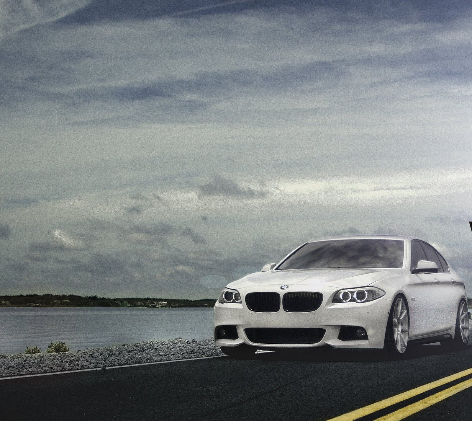 Um carro branco árabe dirigindo em uma estrada ao lado de um corpo d'água (bmw, carro, novo, estrada)