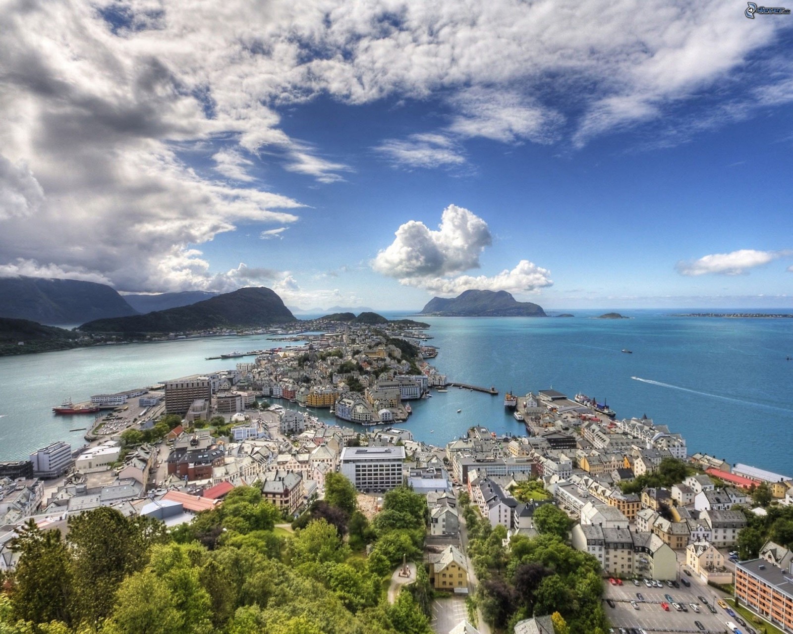 Vista árabe de uma cidade com um corpo d'água e montanhas (fiorde, costa, mar, nuvem, promontório)