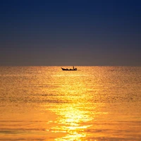 Glowing Dusk: A Boat Glides Across an Amber Ocean Surface