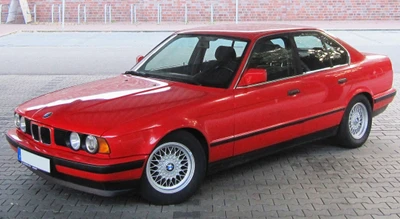 Klassischer roter BMW 3er E36 Limousine mit markanten Drahtfelgen