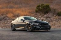 Élégant BMW F82 M4 dans un cadre de coucher de soleil dramatique.