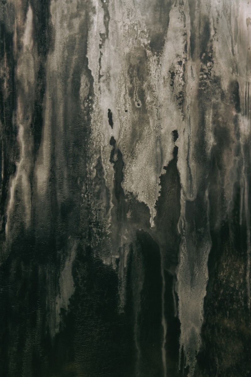 Photo en noir et blanc d'un homme se tenant devant un mur (formation, eau, réflexion, texture, arbre)