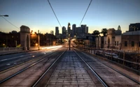 Stadtansicht von Los Angeles bei Dämmerung mit Straßenbahngleisen und Skyline