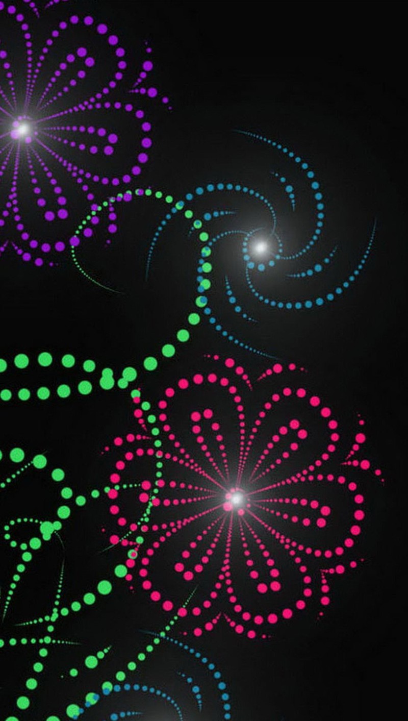 A close up of a clock with a black background and colorful fireworks (flower, glow)