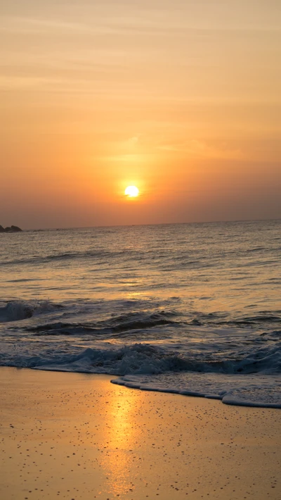 Gelassener Sonnenaufgang über den ruhigen Strandwellen von Sri Lanka